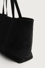 Bolso tipo shopper de piel con acabado serraje, de diseño amplio con compartimento principal y dos asas de hombro.