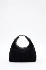 Cartera tipo hobo de Lolita, confeccionada en gamuza color bordó, con diseño de asa integrada y cierre superior. Presenta detalles en cuero liso en los extremos del asa y logo de la marca grabado en el frente.