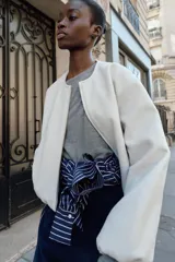 Chaqueta bomber de cuello redondo y manga larga con diseño holgado. Presenta cierre frontal con cremallera, bolsillos delanteros de vivo y acabados elásticos en los puños y el ruedo.