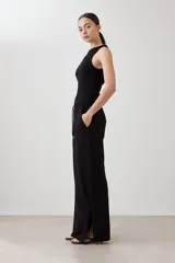 Pantalón de corte amplio y tiro medio, confeccionado en tejido suave de color negro. Presenta una cintura elástica con cordón ajustable y bolsillos laterales amplios.