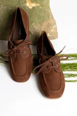 Mocasín de cuero marrón con cordones, diseño de puntera cuadrada y costuras visibles.