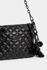 Cartera tipo bandolera de diseño matelasse en color negro, con cierre superior, bolsillo frontal con cierre, tira de hombro con cadena plástica y detalles colgantes de pompones y borlas.
