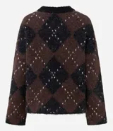 Suéter de punto pesado con diseño de cuadros argyle en tonos marrón y negro, con detalles de puntos claros. Presenta un corte oversize, cuello redondo acanalado y mangas largas.