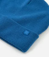 Gorro de punto tipo beanie color tostado, con borde plegado y etiqueta pequeña aplicada en el frente.