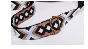 Cartera bandolera de eco-cuero marrón, de diseño redondeado con solapa frontal y bolsillo con cierre. Incluye correa ajustable y desmontable con patrón geométrico.