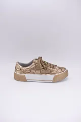 Zapatillas bajas color dorado con diseño trenzado, cordones y suela de goma.