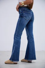 Jean de corte oxford con tiro medio-alto, confeccionado en denim azul con costuras verticales frontales que estilizan la silueta.