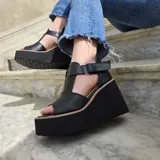 Sandalias de cuero con plataforma corrida, capellada ancha amarilla, detalles en cuero texturizado tipo reptil marrón y tira en el empeine de color blanco con cierre ajustable en el talón.