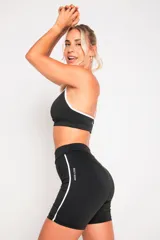 Top deportivo negro de lycra suplex con breteles regulables y contorno blanco.