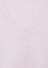Jersey de punto color rosado con cuello en V, manga larga y diseño recto con terminaciones acanaladas.