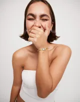 Pulsera de hilo color lima con perla shell y fornitura bañada en plata de ley.