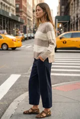 Sweater de punto con diseño de rayas horizontales anchas en color bordó y beige. Presenta cuello redondo con detalle de lurex, mangas largas y puños y ruedo acanalados.