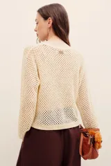 Sweater de punto calado color beige con hilos de lurex, de corte recto, manga larga y cuello redondo con terminación elástica acanalada.