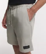 Bermuda masculina de sarga color verde, de corte recto con bolsillos laterales y traseros. Cuenta con cintura elástica y cordón ajustable.