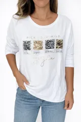 Remera blanca de manga larga, con cuello redondo y corte semi holgado. Presenta un estampado frontal con la frase "PICK YOUR WILD" en dorado y cuatro recuadros con diferentes "animal prints" (pitón, leopardo, cebra y tigre), con detalles en dorado y pedrería.