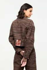 Chaqueta de denim de corte corto en tono marrón con estampado de cebra, cuello camisero, cierre frontal con botones metálicos y bolsillos delanteros con solapa.