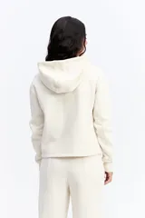Campera tipo hoodie de algodón en color gris oscuro, con cierre frontal completo, capucha con cordones ajustables y bolsillos laterales. Presenta un diseño minimalista con logo bordado sutil en el pecho.