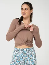 Polera de manga larga color canela, confeccionada en modal, con diseño de nudo frontal y aberturas para los pulgares en los puños.