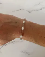 Pulsera de cadena fina de acero con perlas blancas intercaladas.