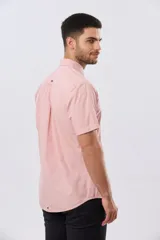 Camisa de manga corta de algodón en color celeste con microdiseño geométrico a cuadros, cuello camisero y bolsillo frontal con logo bordado.