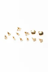 Set de seis pares de aros tipo abridores en tono dorado, con diseños surtidos que incluyen corazones, cristales solitarios, cisnes, formas orgánicas martilladas y tréboles con incrustaciones de pedrería.