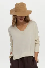 Sweater de punto con lurex en color beige, con escote en V y diseño de corte holgado.