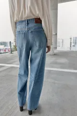 Jeans de tiro alto, color celeste claro con efecto desgastado y lavado. Modelo de corte holgado (loose baggy) con cierre frontal de botones metálicos y cinco bolsillos.