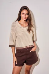 Sweater de tejido abierto de algodón, color beige, con cuello polo, mangas cortas y detalles en color marrón oscuro en los bordes y puños.