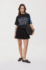 Falda corta blanca con diseño de volados escalonados y cintura elastizada, de silueta fluida y liviana.
