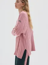 Buzo tejido de punto color beige, con cuello subido, diseño oversized y aberturas laterales en el ruedo.