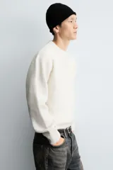 Jersey de punto con textura efecto pelo, corte boxy fit, cuello redondo y manga larga con acabados en rib.