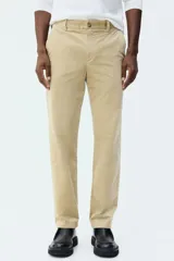 Pantalón de pana de corte regular fit, color beige, con cierre de botón y cremallera, bolsillos laterales y trabillas para cinturón.