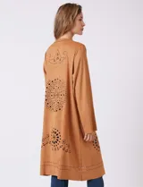 Chaqueta larga color marrón, de símil gamuza calada con diseño de flores y puntos. Tiene silueta abierta y mangas largas de corte recto.