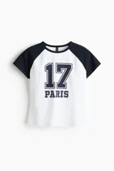 Remera ajustada de punto de algodón, color blanco con mangas raglán en azul marino y diseño estampado frontal con el número 17 y la palabra Paris.
