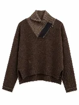 Polera de lana lambswool color marrón, con cuello alto y cierre lateral. Presenta diseño de rombos en las mangas, detalle de raya en contraste en los puños y tajos laterales en el ruedo.