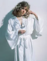 Kimono largo de seda blanca con mangas amplias y cinturón ajustable del mismo género.