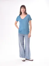 Remera blanca de manga corta con escote en V, de tejido ligero y ligeramente traslúcido.