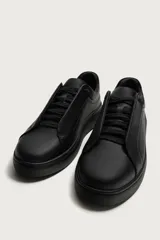 Zapatilla urbana de diseño minimalista en color blanco, con cordones ocultos y suela de plataforma a tono.
