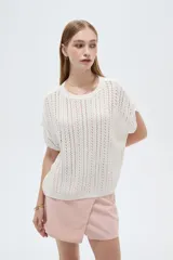 Remera de manga corta de acrílico en tejido calado, con cuello redondo y diseño ajustado.