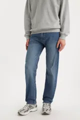 Jeans de corte regular fit en color azul medio, con diseño clásico de cinco bolsillos y cierre frontal con botón y cremallera.