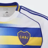 Camiseta de fútbol Adidas del Boca Juniors, tercer uniforme. Diseño blanco con franjas horizontales en azul y amarillo con efecto degradé, cuello redondo y mangas cortas con detalles en azul y amarillo. Incluye logo de Adidas, escudo del club y sponsor betsson en el frente.