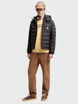 Campera puffer Moncler modelo Ravenlock, color negro, con capucha desmontable, cierre frontal de cremallera y bolsillo en el pecho con solapa y botón a presión con insignia de la marca.