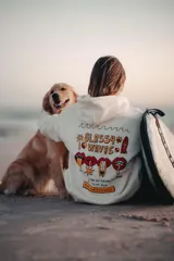 Hoodie color natural con estampado en la espalda con la frase "Glassy Waves" y dibujos de palmeras, labios y tablas de surf.