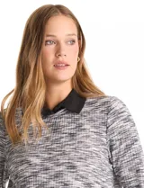 Buzo de tejido fino con efecto melange en tonos tierra, que incorpora cuello y ruedo inferior en tela tipo gasa negra, simulando una camisa debajo. Posee mangas largas y un diseño de corte recto.