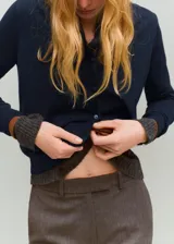 Cardigan de punto fino azul marino, confeccionado en mezcla de algodón y lana, de corte recto con cuello redondo, manga larga y cierre frontal de botones.