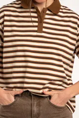 Remera polo de manga corta con diseño a rayas horizontales en tonos marrones, beige y negros, cuello en contraste y cierre frontal de botones.