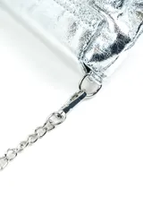 Cartera plateada de efecto metalizado con textura craquelada, solapa frontal con detalle geométrico y correa de cadena metálica removible.