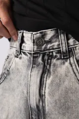 Bermuda de jean con lavado ácido, corte mom y estilo carpintero con bolsillos laterales utilitarios.