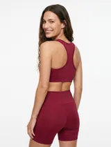 Top deportivo negro con diseño de espalda deportiva y escote redondo.