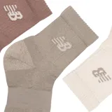 Pack de tres pares de medias New Balance Active Cushion, unisex, en colores marrón, gris y beige, con logo de la marca en el tobillo.